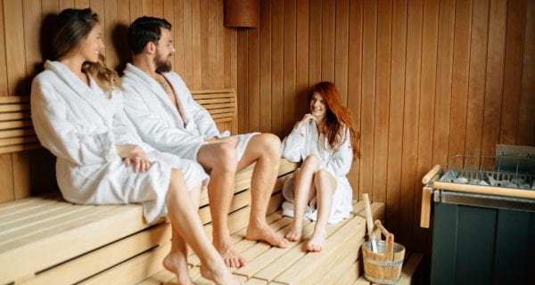 Drie mensen ontspannen in een sauna